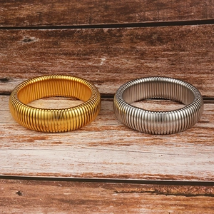 Close-up of flexible titanium steel bracelets in gold and silver with spiral snake bone texture