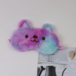 Detail of plush bear sleep mask with purple and pink gradient fur and cute embroidery