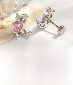 Detailed view of silver screw back earring with pink heart zircon and moon star design