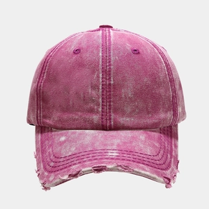 Macro detail of washed distressed denim baseball cap with vintage frayed brim holes
