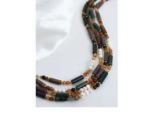 Detailed shot of dark green agate beads and white freshwater pearls on a beaded necklace