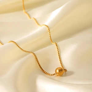 Elegant 18K gold stainless steel box chain necklace with bead pendant on beige silk fabric