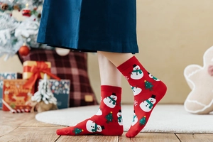 Nahaufnahme roter Weihnachts-Baumwollsocken mit weißen Schneemännern und Tannen