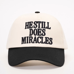 Adjustable baseball cap with HE STILL DOES MIRACLES embroidery in beige and black