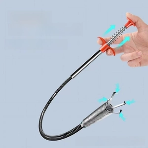 Macro view of four-claw drain cleaner tool with red handle for sink hair removal