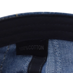 Close-up of the 100% cotton inner lining and washing label of the denim beret cap