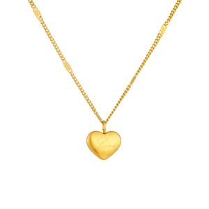 Detailed close-up of a gold-plated heart pendant with Love engraving on a chain