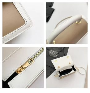 Detail view of contrast stitching, gold zippers, and interior of the bicolor handbag