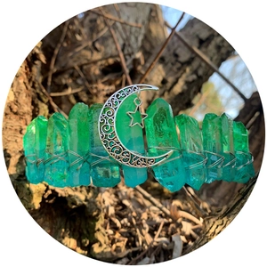 Natural green crystal crown with silver crescent moon and star charms on bark background