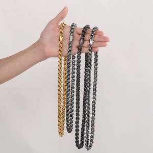 Detailed view of punk skull link necklaces in gold, silver, and gun black finishes