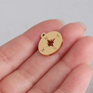 Golden stainless steel compass charm pendant with cutout star and N E S W direction letters
