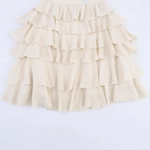 Chic cream tiered ruffle midi skirt featuring lightweight layered fabric with subtle texture