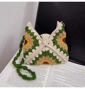 Detail of handmade crochet sunflower bag with pearl closure on an open vintage book