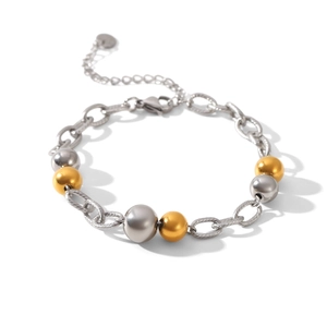Détail d'un bracelet chaîne bicolore en acier inoxydable avec sphères polies or et argent