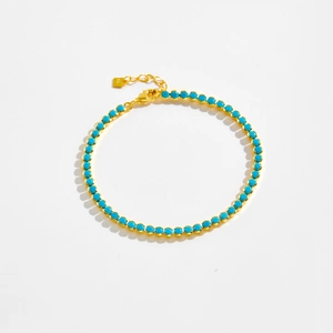 Close-up of S925 sterling silver stamp on golden chain with blue beads