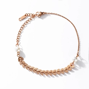 Bracelet en acier titane or rose avec feuilles de blé et perles sur fond blanc épuré