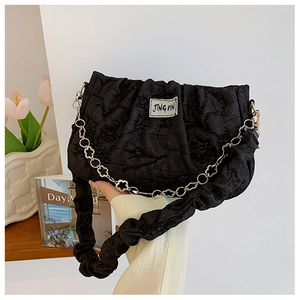 Detail of black pleated shoulder bag with floral silver chain and textile brand label