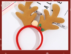 Detail of Christmas reindeer antler headband with festive red berries and soft plush balls