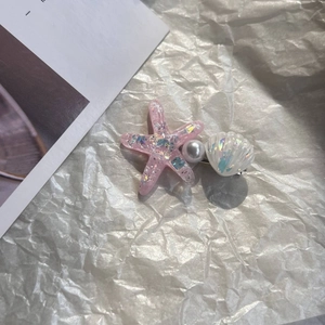Detail of pink glitter starfish, pearl and iridescent shell hair clip for girls