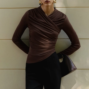 Detail showing the overlapping V-neck and ruched texture of the brown long-sleeve top