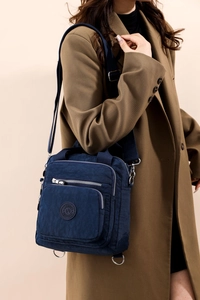 Détail du sac à langer en nylon bleu marine avec bandoulière réglable sur un mannequin