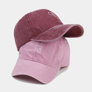 Detail of washed cotton baseball caps with vintage texture and puppy embroidery