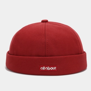 Detailed close-up of dark red docker hat featuring white all about embroidery label