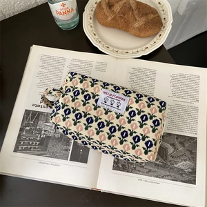 Détail de la trousse de toilette en velours côtelé avec motifs tulipes et zip