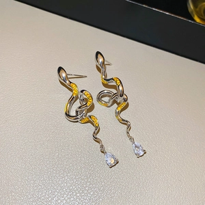 Detail of silver snake earrings with yellow patterns and pear-cut zircon drops