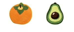 Detail of plush persimmon and avocado fruit shaped bath mats with thick tufted texture