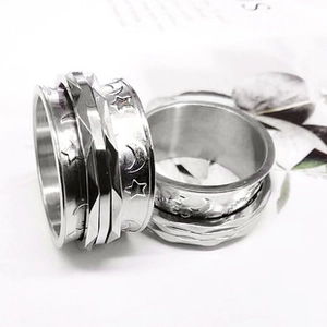 Detail of silver spinner ring with engraved moon and stars pattern on stainless steel