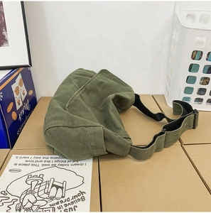 Detailed view of the green washed canvas fabric and adjustable strap of the messenger bag