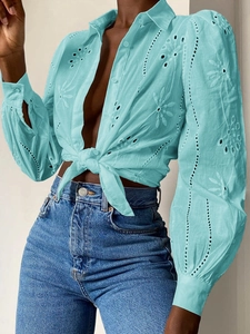 Detail of lake blue eyelet embroidery and tie-front design on casual long sleeve shirt