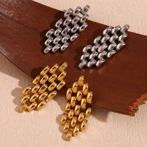Detailed macro shot of 18K gold and silver plated stainless steel watch-link earrings