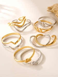 Detailed macro view of gold and silver wave-patterned stainless steel bangles