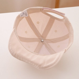 Détail de l'étiquette 100% coton et des coutures internes de la casquette enfant