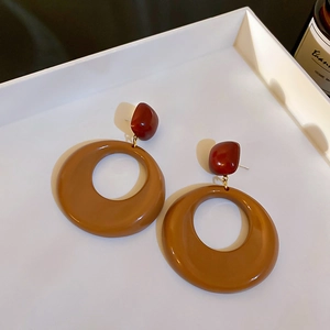 Détail de boucles d'oreilles vintage en acrylique avec anneaux en résine marron