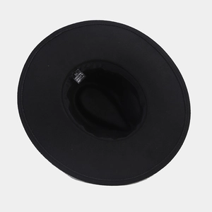 Detail view of the black wide brim hat showing the size 57 and polyester material label