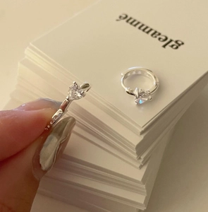 Detail of silver S925 heart-shaped zircon earrings with secure hoop clasp closure