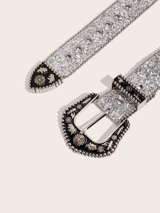Close-up of western-style buckle with star and floral motifs on silver glitter belt