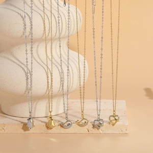 Detail view of gold and silver penguin and whale pendants with zircon on necklaces