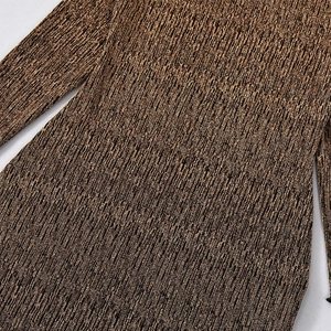 Détail macro d'un tissu en maille bronzée avec texture côtelée et reflets dorés fins