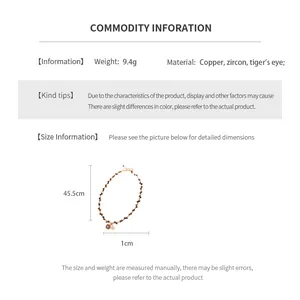 Détail du collier de perles en œil de tigre plaqué or 18 carats et charm en zircon
