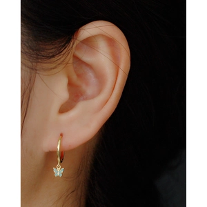 Close-up of a gold s925 silver hoop earring featuring a delicate blue crystal butterfly pendant