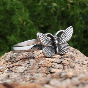 Vintage butterfly ring in antique silver finish on natural tree bark background