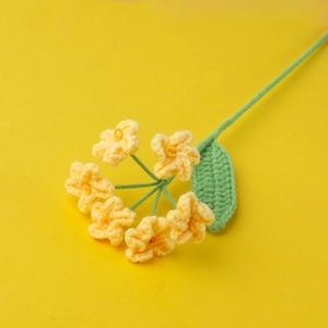 Detailed knit forget-me-not flower in bright yellow yarn with green leaf and stem