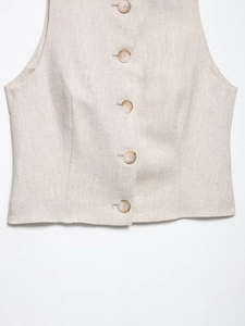 Detailed close-up of beige cotton vest featuring classic amber resin buttons and fabric texture