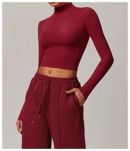 Detail of dark red sportswear set with cropped high neck top and wide-leg joggers