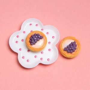 Top view of miniature grape tarts on a floral plate for dollhouse DIY projects