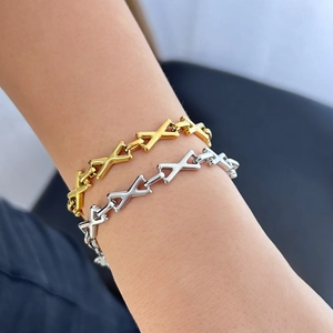 Elegant gold and silver X-link titanium steel bracelets worn on a model's wrist